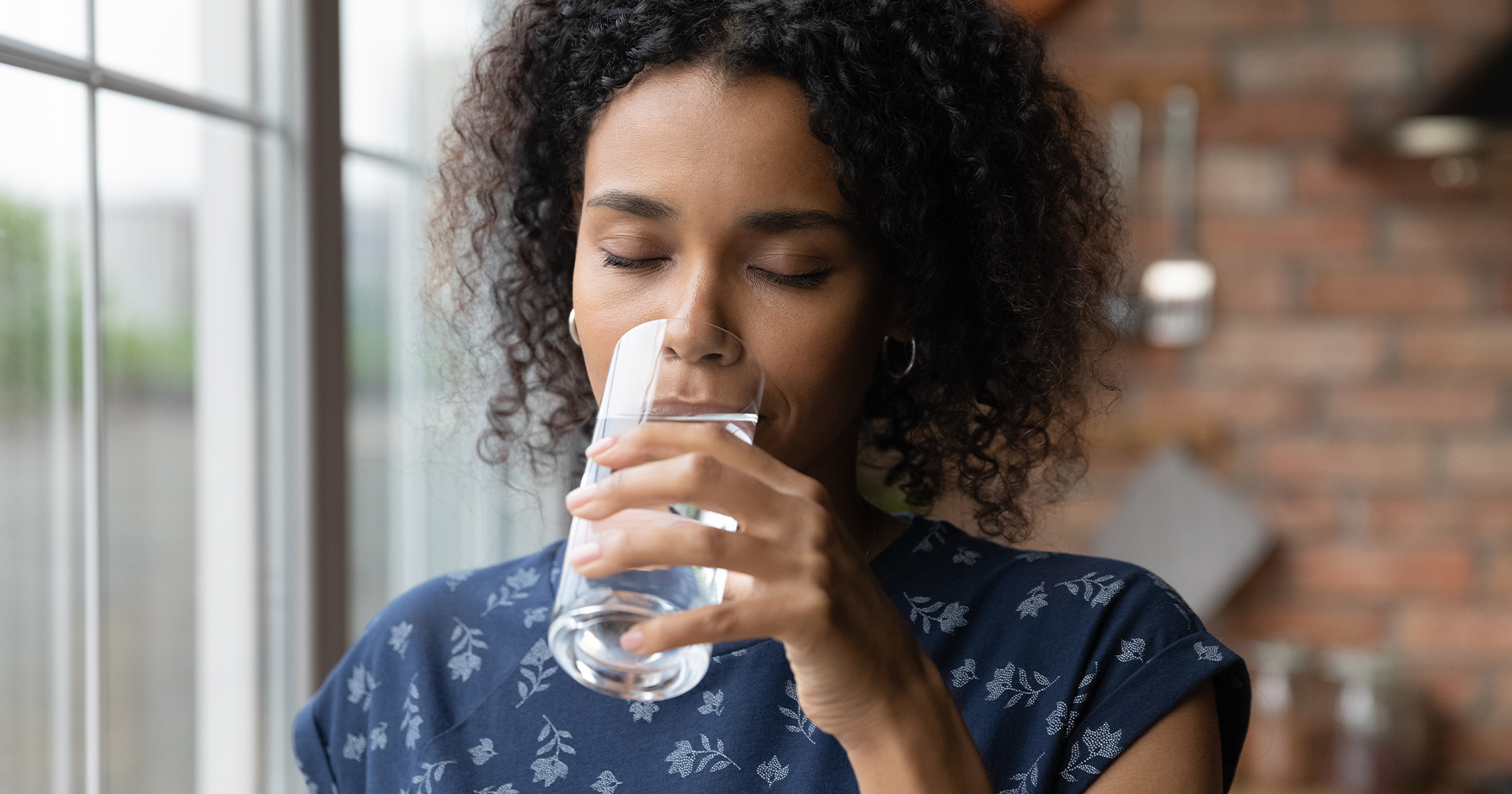 Image of a woman drinking a glass of water.